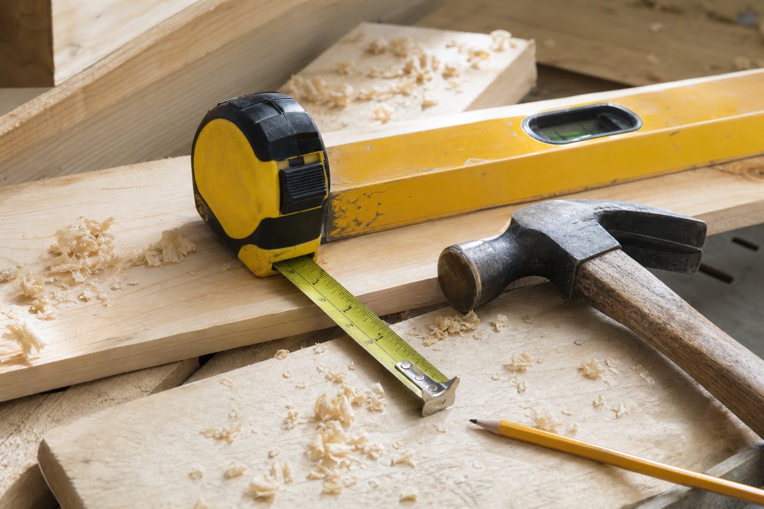 Concept image of carpentry tools laid out on raw wood